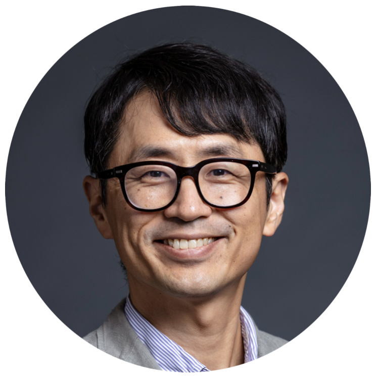 Portrait of a man wearing glasses and a blazer against a neutral studio background with a calm, professional expression